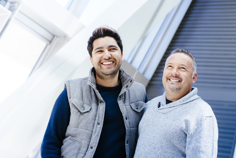 Older and younger man smiling at camera
